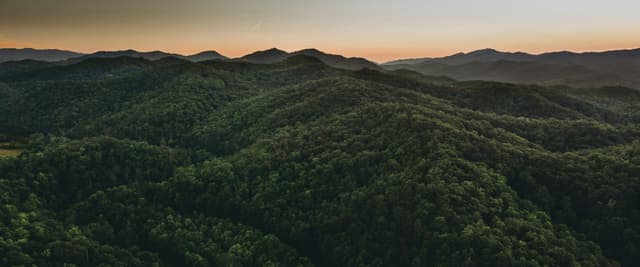Aerial view of forested mountain ridgelines at sunset in North Georgia